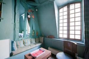 a blue room with a couch and a window at Appartement charmant à Troyes avec cour intérieure clôturée - 50 m² in Troyes