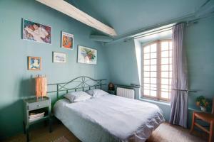 a bedroom with blue walls and a bed with a window at Appartement charmant à Troyes avec cour intérieure clôturée - 50 m² in Troyes