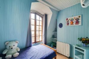 a bedroom with a teddy bear sitting on a bed at Appartement charmant à Troyes avec cour intérieure clôturée - 50 m² in Troyes +8 photos