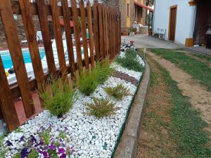 a fence with flowers in a garden next to a pool at Spacious villa with pool in Empalme de Vilar - 300 m², 8 guests in Vilar