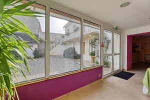 a room with large windows and a courtyard at Maison spacieuse avec jardin près de Le Bouffay in Commes