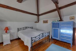 a bedroom with a blue dresser and a bed at Maison spacieuse avec jardin près de Le Bouffay in Commes