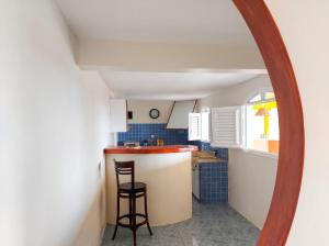 a kitchen with a counter and a stool in a mirror at Maison charmante à Le Diamant avec vue sur mer et jardin in Le Diamant