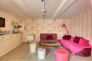 a living room with a pink bed and a chair at Maison spacieuse avec jardin près de Le Bouffay in Commes +23 photos