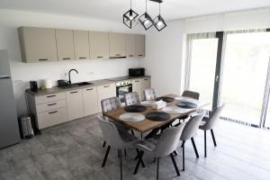 a kitchen and dining room with a table and chairs at Casa Andrei Guesthouse in Bărăşti