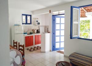 a kitchen with red cabinets and a white refrigerator at Appartement confortable à Le Marin, jardin, 80 m², proche mer in Le Marin