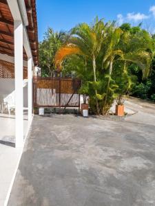 a patio with a fence and a palm tree at Appartement confortable à Le Marin, jardin, 80 m², proche mer in Le Marin