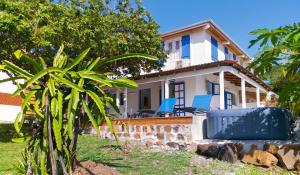 a house with blue chairs in front of it at Appartement confortable à Le Marin, jardin, 80 m², proche mer in Le Marin +14 photos