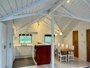 a kitchen and dining room with a wooden table and chairs at Sønderborg Wellness Villa in Skovbyballe