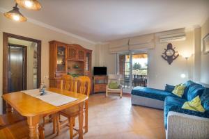 a living room with a table and a blue couch at Inmacanela playa in Isla Canela