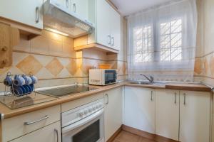 a kitchen with white cabinets and a microwave at Inmacanela playa in Isla Canela