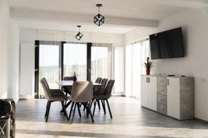 a dining room with a table and chairs at Casa Andrei Guesthouse in Bărăşti +40 photos