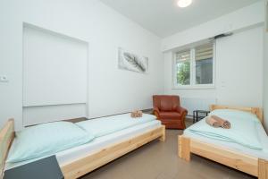 a bedroom with two beds and a chair at Penzion Anareta in Frýdek-Místek