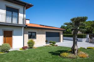 a house with a tree in the front yard at Cosy Chalet in Várzea with Private Pool in Várzea
