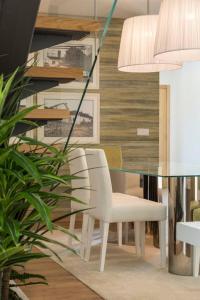 a dining room with a glass table and a white chair at Cosy Chalet in Várzea with Private Pool in Várzea +36 photos