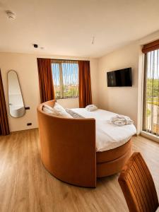ein Hotelzimmer mit einem großen Bett und einem Stuhl in der Unterkunft Hotel het Dok in IJmuiden