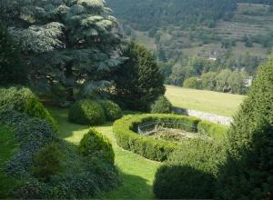 a garden with bushes and trees in a field at Manoir majestueux à Satillieu avec piscine privée in Satillieu