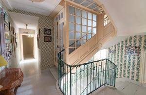 a hallway with a spiral staircase with a window at Manoir majestueux à Satillieu avec piscine privée in Satillieu