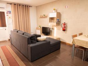 a living room with a couch and a television at Comfortable House in Marinhas + Garden and Sea View. in Marinhas