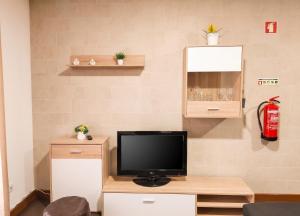 a living room with a television on a wooden table at Comfortable House in Marinhas + Garden and Sea View. in Marinhas