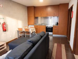a living room with a couch and a kitchen at Comfortable House in Marinhas + Garden and Sea View. in Marinhas