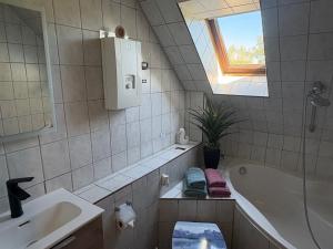 a bathroom with a sink and a tub and a window at Ferienwohnung Nordstadt in Forst