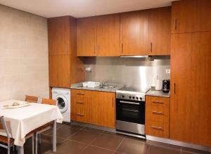 a kitchen with wooden cabinets and a stove top oven at Comfortable House in Marinhas + Garden and Sea View. in Marinhas +16 photos