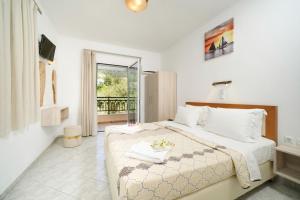 a bedroom with a large bed and a balcony at Apartments Apollonio in Chrysi Ammoudia
