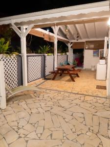 an outdoor patio with a table and a stone floor at Appartement cosy à Sainte Rose / 50 m² / Piscine partagée in Diavet