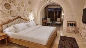 a bedroom with a large bed and a stone wall at Shamas Hotel in Midyat