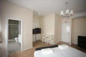 a large white room with a table and a kitchen at Suites Guest House in Cascais
