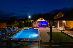 a house with a swimming pool in the yard at night at Peaceful Villa in Gornje Dubrave with Private Pool in Gornje Dubrave