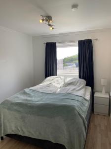 a bedroom with a bed and a window at Sentrumsnær sokkelleilighet in Svolvær