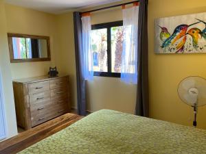 a bedroom with a bed and a window and a dresser at Cosy apartment in Corralejo, shared pool, 55 m² in Corralejo