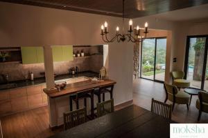 eine Küche mit Tisch und Stühlen in einem Zimmer in der Unterkunft Tea & Tranquility by Moksha Stays in Vagamon