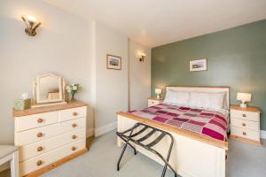 a bedroom with a bed and a dresser and a mirror at 1 Bed in Appledore oc-captv in Appledore