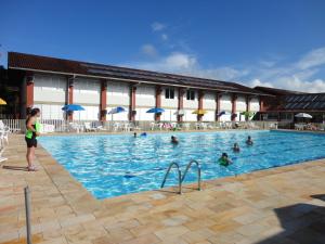 a group of people swimming in a swimming pool at FECEP Pousada - 5 minutos a pé da praia in Guaratuba