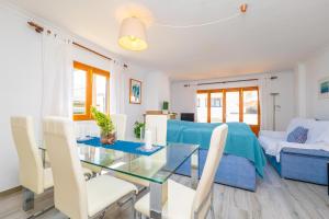 a living room with a glass table and white chairs at PDM CA'N NOFRE in Playa de Muro