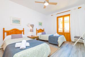 a bedroom with two beds and a ceiling fan at PDM CA'N NOFRE in Playa de Muro