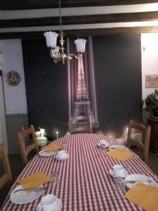 une table avec un tissu de table rouge et blanc et une tour d'eiffel dans l'établissement Le Champ Bouchon - Chambres d'hôtes, à Tréban