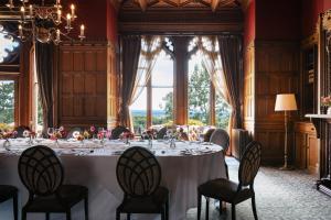 a long table in a room with a large window at Nutfield Priory Hotel & Spa in Redhill