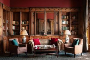 a living room with two chairs and a couch at Nutfield Priory Hotel & Spa in Redhill