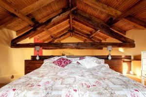 a bedroom with a large bed with wooden ceilings at Charming Villa with Private Pool in Vesime in Vesime