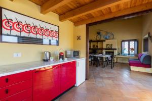 a kitchen with red cabinets and a living room at Charming Villa with Private Pool in Vesime in Vesime