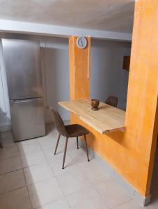 a kitchen with a wooden table and a refrigerator at Appartement charmant à Sainte-Rose avec terrasse et jardin in Sainte-Rose +4 photos