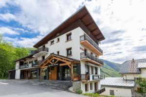 a large white building with a wooden roof at Appartement Douillet Saint-Sorlin-d'Arves 49 m² Vue montagne in Saint-Sorlin-dʼArves