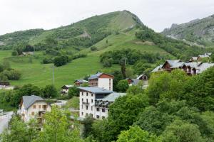 a village in the mountains with houses and trees at Appartement Douillet Saint-Sorlin-d'Arves 49 m² Vue montagne in Saint-Sorlin-dʼArves +4 photos