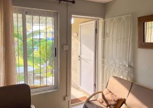a room with a door and a chair and a window at Charming Studio in Grand Baie, 60 m² with Shared Pool in Grand-Baie