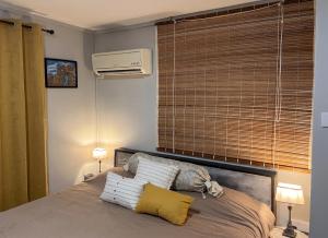 a bedroom with a bed with two pillows and a air conditioner at Charming Studio in Grand Baie, 60 m² with Shared Pool in Grand-Baie