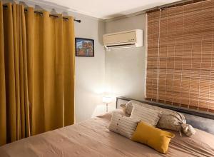 a bedroom with a bed with yellow curtains and a heater at Charming Studio in Grand Baie, 60 m² with Shared Pool in Grand-Baie